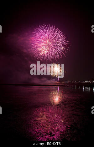 Musselburgh, Scozia, Regno Unito, 5 nov. 2018. Guy Fawkes fuochi d'artificio riflessa nella sabbia bagnata. Insolitamente mite a 9 gradi per la East Lothian town annuale gratis Fireworks display a cui hanno partecipato anche a più persone a causa della chiusura di Edimburgo di Meadowbank Stadium. Foto Stock