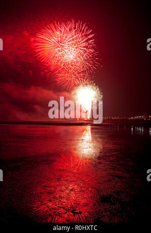 Musselburgh, Scozia, Regno Unito, 5 nov. 2018. Guy Fawkes fuochi d'artificio riflessa nella sabbia bagnata. Insolitamente mite a 9 gradi per la East Lothian town annuale gratis Fireworks display a cui hanno partecipato anche a più persone a causa della chiusura di Edimburgo di Meadowbank Stadium. Foto Stock