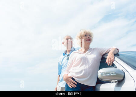 Due senior persone sorridenti con fiducia mentre appoggiate su di loro Foto Stock