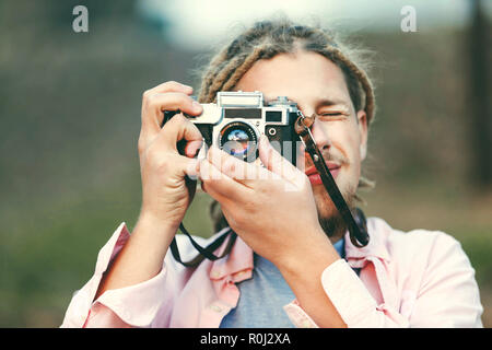 Hipster bionda fotografia barbuto ragazzo con i timori di scattare le foto sulla natura percorso nella foresta, outdoor view Foto Stock