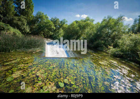 Una cascata e un ponte sul Canal Grande Union, Regno Unito, vicino Rickmansworth Foto Stock