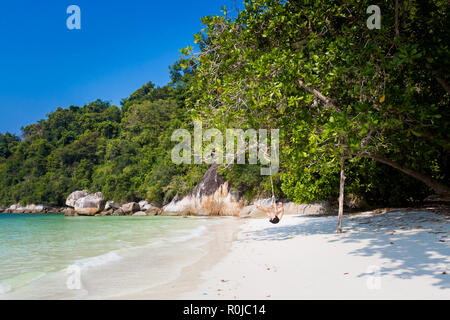 Giovane turista rilassante per semplice rotazione sulla spiaggia segreta sull Isola di Pangkor in Malaysia. Bellissimo paesaggio marino e il porto preso nel sud est asiatico. Foto Stock