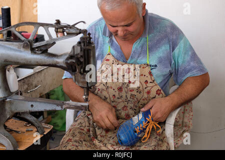 Il comando cobbler il fissaggio di un gancio di calcio a Kemer, Turchia Foto Stock