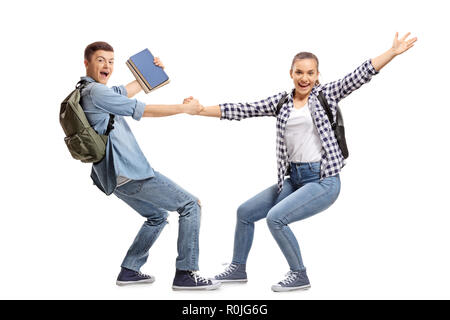 A piena lunghezza shot di allegro studenti maschi e femmine holding hands isolati su sfondo bianco Foto Stock