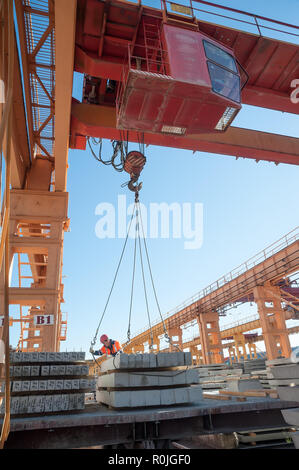 Tyumen, Russia - Agosto 13, 2013: magazzino prodotti finiti a merci concrete impianto n. 5. L'anello tubolare accetta piastre dal gruista di caricamento railwa Foto Stock