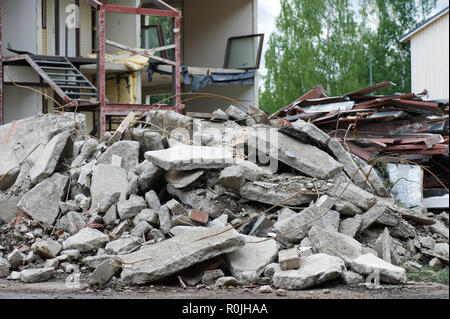 Pila di calcestruzzo di fronte parzialmente demolito casa. La messa a fuoco in primo piano. Foto Stock