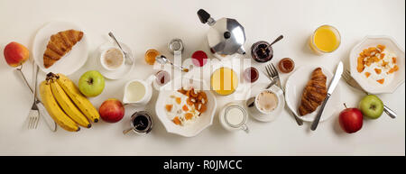 Il momento della colazione. Croissant e succo d'arancia, marmellata e miele. Caffè con panna o latte. Frutta - banane, il rosso e il verde di mele. Ricotta con panna acida Foto Stock