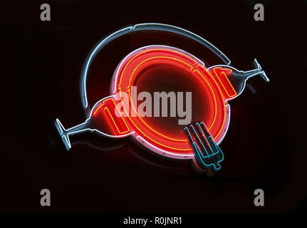 Il Neon segno luminoso nella forma di una piastra di bicchieri di vino e delle forcelle Foto Stock