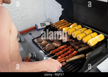 L'uomo la preparazione della cena sul barbecue Foto Stock