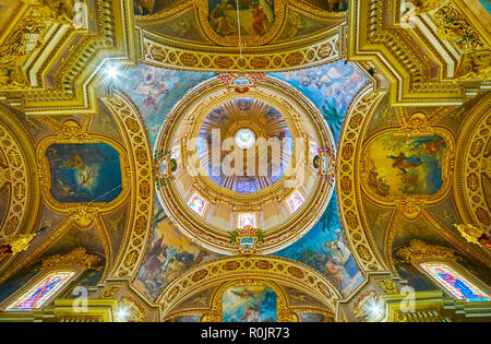 NADUR, Malta - 15 giugno 2018: riccamente decorata cupola di San Pietro e Paolo Basilica con affreschi colorati e scolpiti in stucco ghirlande, il 15 giugno a Foto Stock