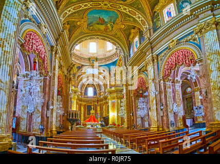 NADUR, Malta - 15 giugno 2018: la splendida sala da preghiera di san Pietro e Paolo Basilica con colonne in pietra e ornato di lampadari di vetro, il 15 giugno a Na Foto Stock