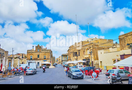 XAGHRA, Malta - 15 giugno 2018: la piazza davanti alla Basilica della Natività con molti turisti le caffetterie e i bar, il 15 giugno a Xaghra. Foto Stock