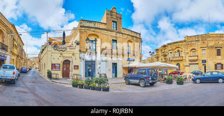 XAGHRA, Malta - 15 giugno 2018: Panorama dei vecchi edifici in piazza centrale con caffè all'aperto e negozi di piccole dimensioni, il 15 giugno a Xaghra. Foto Stock