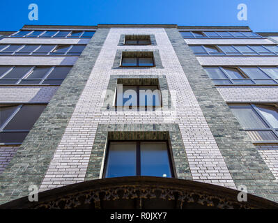 Frammento della facciata di un edificio moderno a cinque piani di mattoni di edificio di appartamenti Foto Stock