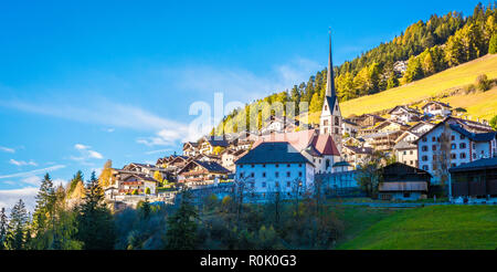 Paesaggio autunnale in Val Gardena. La città di Santa Cristina (St. Christina in Groden) con la luce del tramonto, situato nel cuore di Dolomit Foto Stock