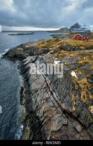 Clif con tradizionale rosso rorbu casa sulle Isole Lofoten in Norvegia Foto Stock