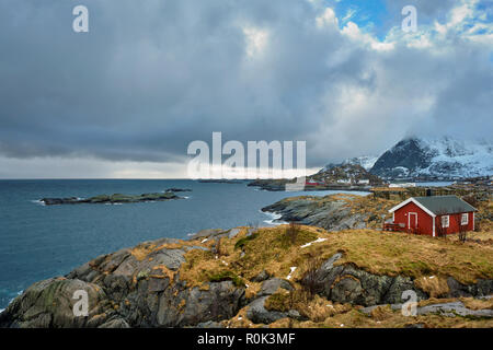 Clif con tradizionale rosso rorbu casa sulle Isole Lofoten in Norvegia Foto Stock