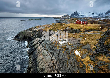Clif con tradizionale rosso rorbu casa sulle Isole Lofoten in Norvegia Foto Stock