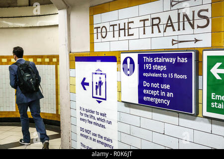 Londra Inghilterra,UK,Covent Garden stazione della metropolitana treno metropolitana, metropolitana, uomo uomo maschio, passeggeri passeggeri motociclisti, penduter, segnali di avvertimento, emerg Foto Stock