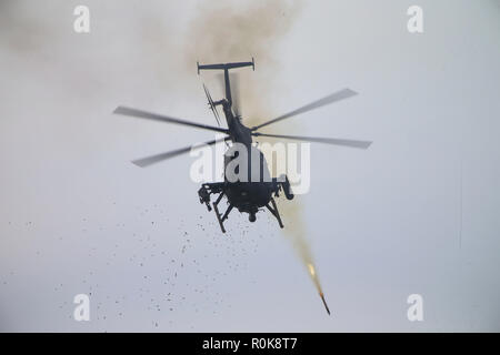Un U.S. Esercito AH-6 uccello piccolo elicottero sparare razzi al bersaglio. Foto Stock