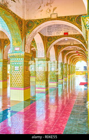 MANDALAY, MYANMAR - Febbraio 23, 2018: la bellissima galleria di Su Taung Pyae Tempio con wirrorwork decorazioni e affreschi sulle arcate su Februa Foto Stock