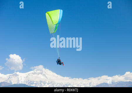 Parapendio in tandem galleggiare sopra il Nepal con l'Annapurna Himalaya in background Foto Stock