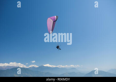 Parapendio in tandem galleggiare sopra il Nepal con l'Annapurna Himalaya in background Foto Stock