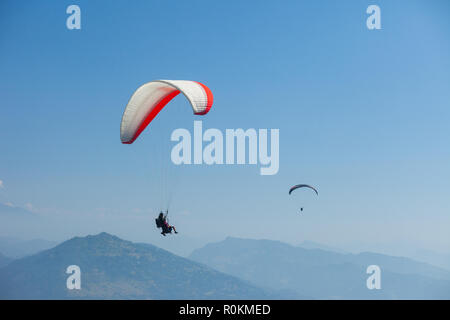 Parapendio in tandem galleggiare sopra il Nepal con l'Annapurna Himalaya in background Foto Stock