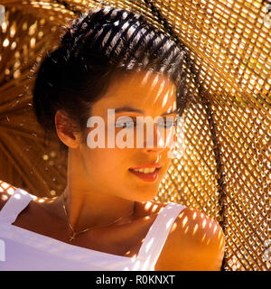 Giovane donna ritratto, guardando dal lato, sullo sfondo di vimini, Guadalupa, French West Indies, Foto Stock