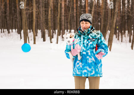 Donna di mezza età all aperto con cute cane - Jack Russell Terrier nella stagione invernale Foto Stock