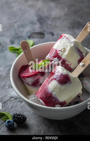 Berry popsicles su sfondo rustico Foto Stock