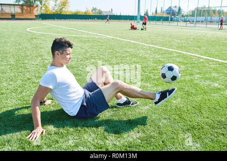 Giovane uomo a giocare il gioco del calcio Foto Stock