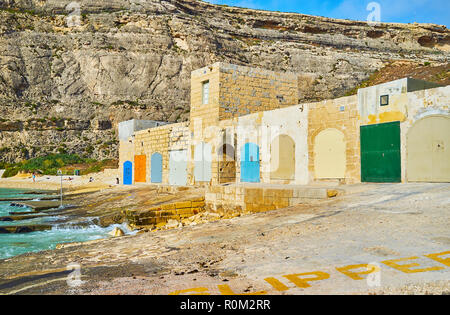 La barca di pietra case colorate con le porte situate sulla riva di Dwejra Inland Sea - la famosa località turistica sull isola di Gozo, Malta. Foto Stock