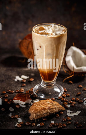 Latte di cocco smoothie con caffè e latte di cocco e pezzi di noce di cocco Foto Stock