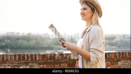 Felice donna turista in vacanza con la mappa della città in visita Foto Stock