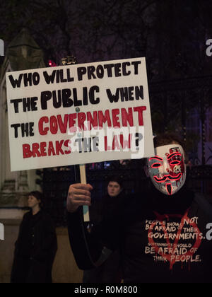 Londra, Regno Unito. 5 novembre 2018. Primo piano di un manifestante anonimo con una maschera Guy Fawkes e un cartello visto su Trafalgar Square la sera del 5 novembre 2018 protestando contro il governo. Credit: Joe Kuis / Alamy Live News Foto Stock