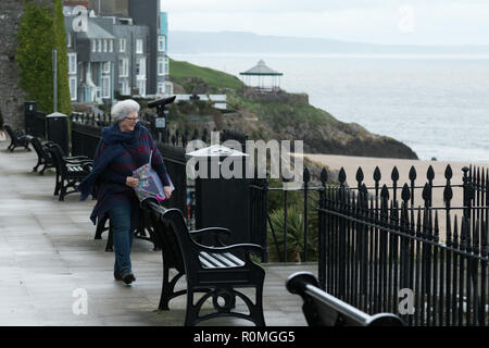 Tenby, Pembrokeshire, West Wales, Regno Unito. 6 novembre 2018. Regno Unito meteo: Heavy Rain e gales presso la costa di oggi. Una donna battaglie contro il vento. Credito: Andrew Bartlett/Alamy Live News Foto Stock