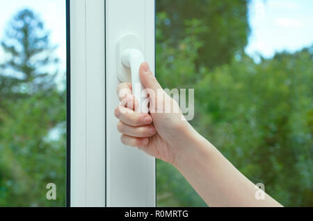 Una donna si apre a mano l'anta della finestra. Close-up. Foto Stock