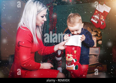 Carino il bambino e la madre con calza di Natale Foto Stock