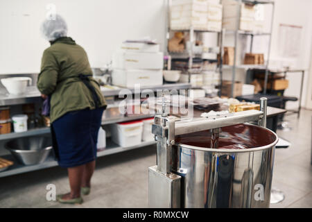 Lavoratore preparare gli ingredienti in una cioccolata factory Foto Stock