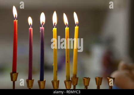 Chanukah colorati candele accese in un dorato menorah Foto Stock