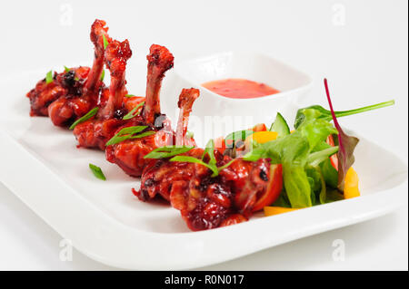 Frittura di ali di pollo in salsa di melograno Foto Stock