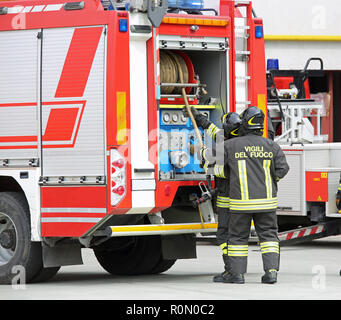 Italia, Italia - 10 Maggio 2018: rosso fuoco carrello e due taliana vigili del fuoco con uniforme durante il drill incendio. Il testo Vigili del fuoco significa per i vigili del fuoco in esso Foto Stock