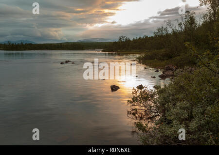 Fiume Rautas al tramonto in estate con colori caldi nel cielo che riflette nell'acqua, Kiruna county, Lapponia svedese, Svezia Foto Stock