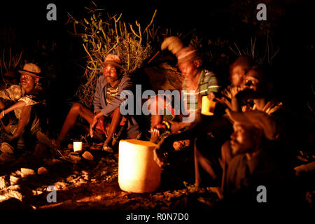 Gli uomini socializzare da un incendio in quanto bere una birra fatta in casa in un Pokot comunità di pastori e nella contea di Baringo, Kenya, 1 ottobre 2018. Foto Stock