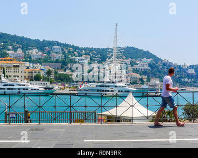 Uomo che guarda grande e lussuoso yacht bianca ormeggiata Nizza Francia view bridge, ricchi concetto, miglior concetto di vita ricca di stile di vita vita, obiettivi, raggiungere stelle Foto Stock