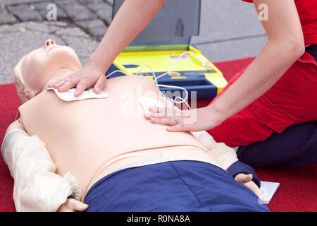 Formazione di primo soccorso con defibrillatore automatico esterno - dispositivo AED. La pratica sul manichino CPR. Foto Stock