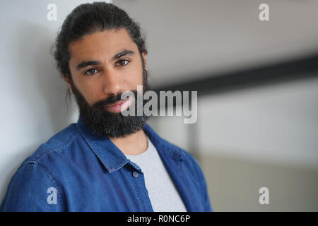 Ritratto di barbuto dai capelli scuri con uomo maglietta blu Foto Stock
