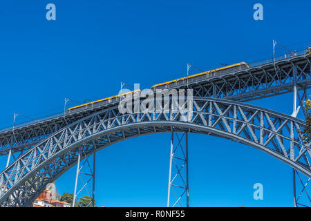 Vista del ponte metallico di D. Maria Pia, costruito da Gustave Eiffel, con metropolitana gialla carro, a Porto, Portogallo Foto Stock