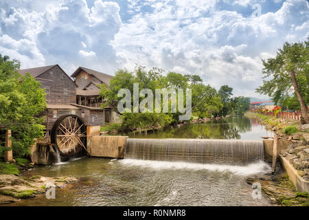 Foto orizzontale di un fiume e il vecchio mulino con il cielo blu con nuvole e gli alberi che riflette nell'acqua. Foto Stock